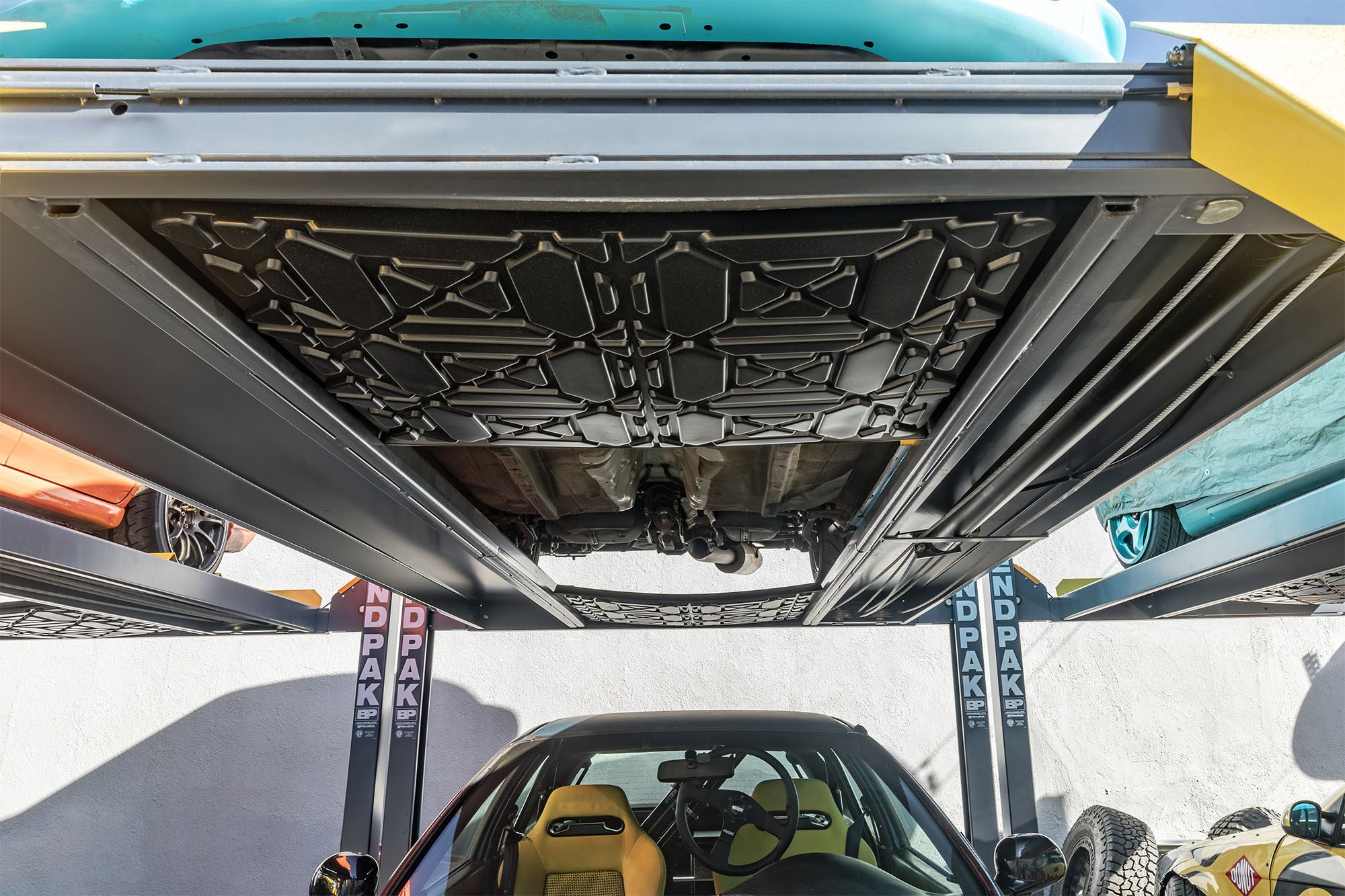 BendPak drip tray accessory for keeping lower vehicles clean during stacked storage.