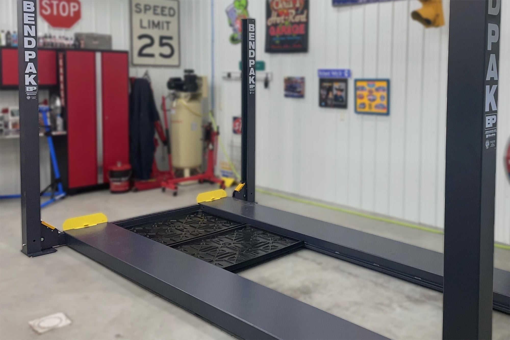 BendPak plastic drip trays installed on a four-post lift in a garage