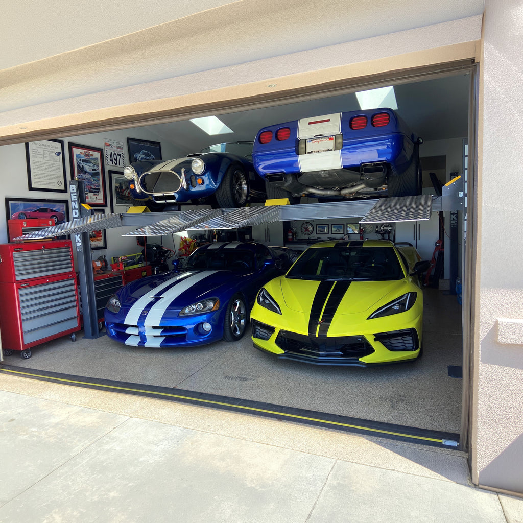 BendPak HD-9SWX dual-platform lift supporting vehicles in a residential garage.