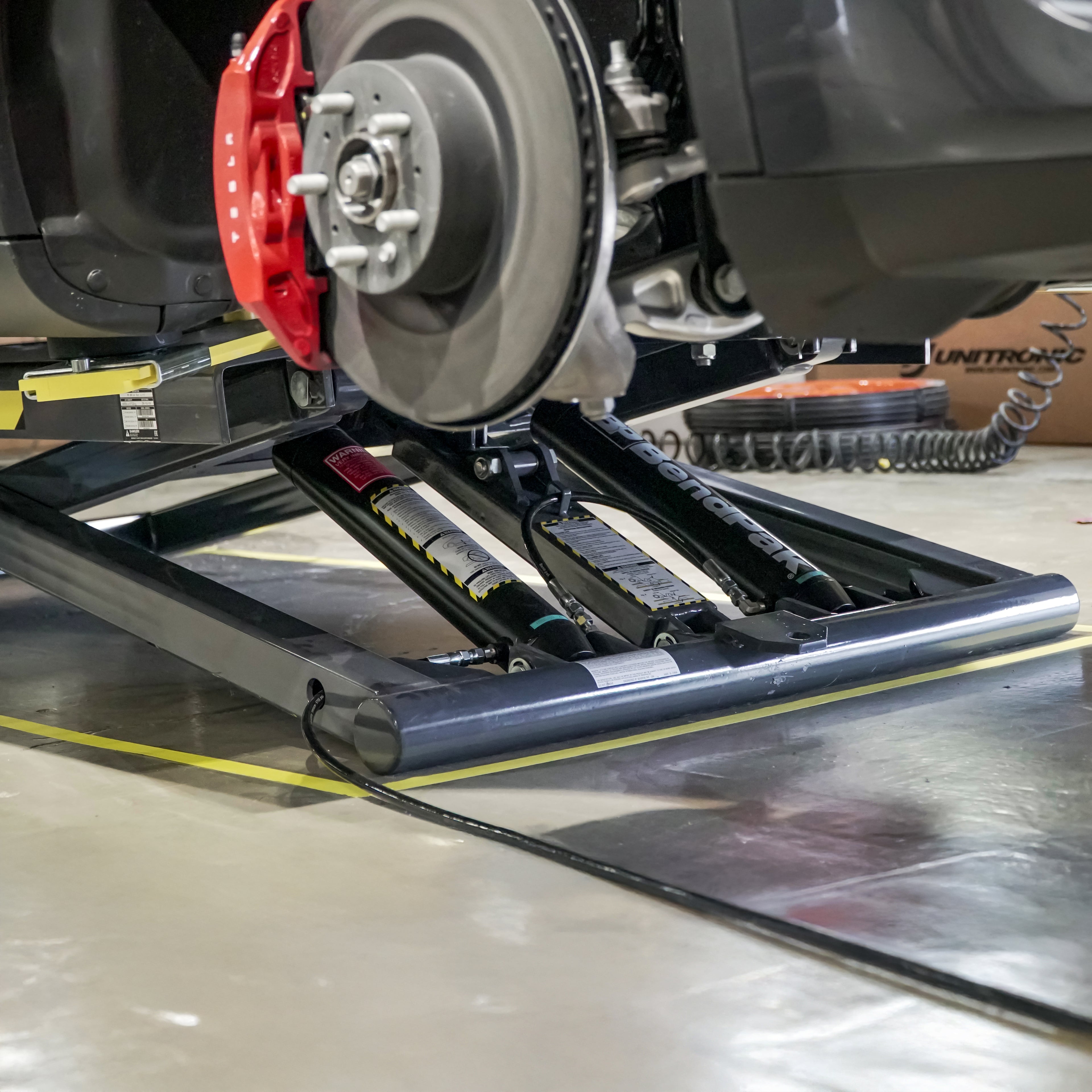 BendPak MD-6XP portable mid-rise scissor lift showing 360-degree rotating arms for vehicle positioning.