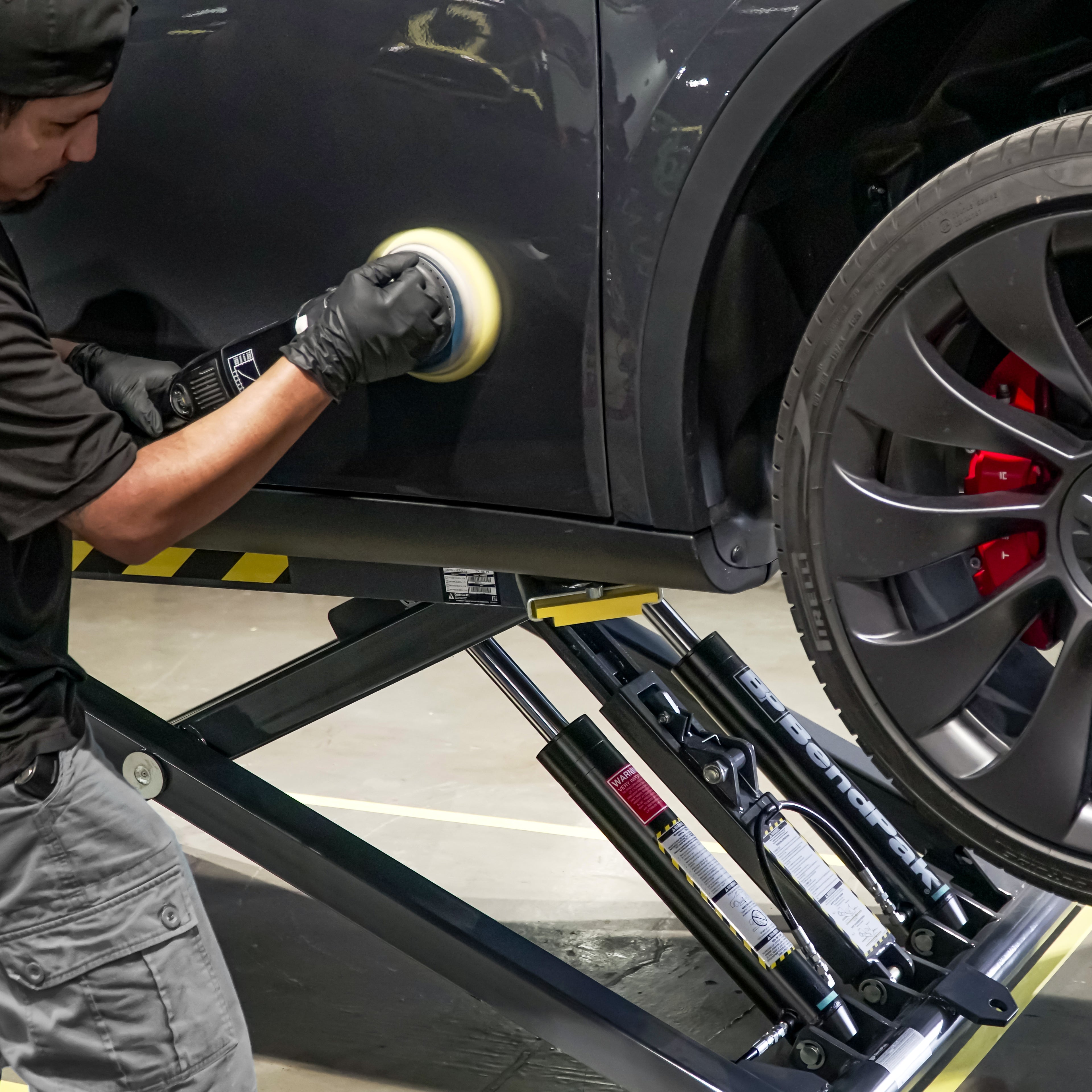 BendPak MD-6XP portable mid-rise scissor lift raising a car for frame-engaging detailing access.