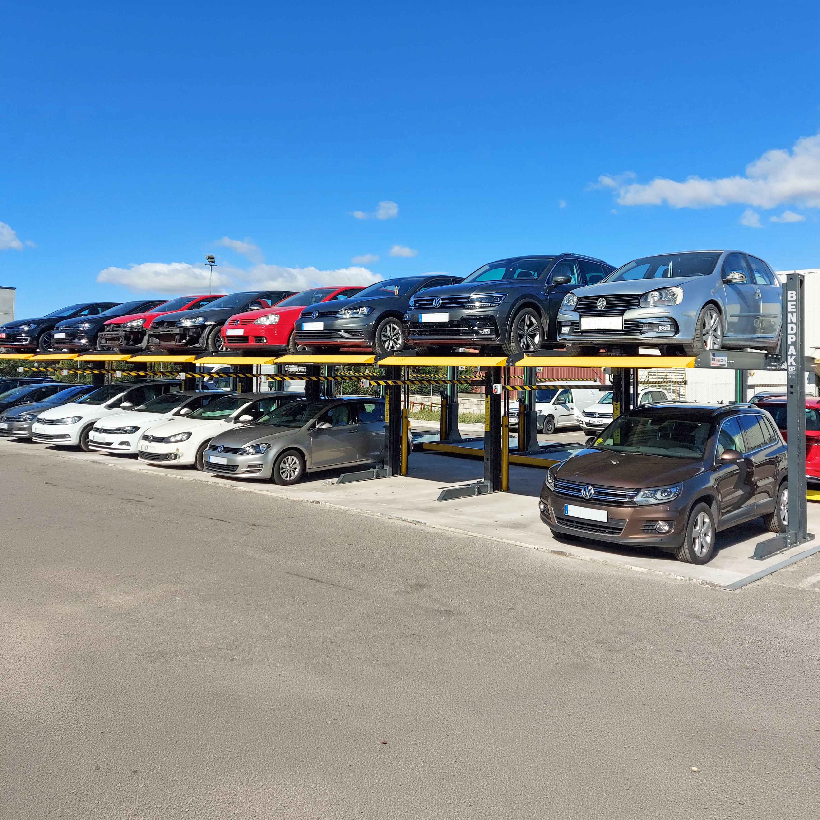 BendPak PL6000DC shared-column parking lift with a space-saving minimal footprint.