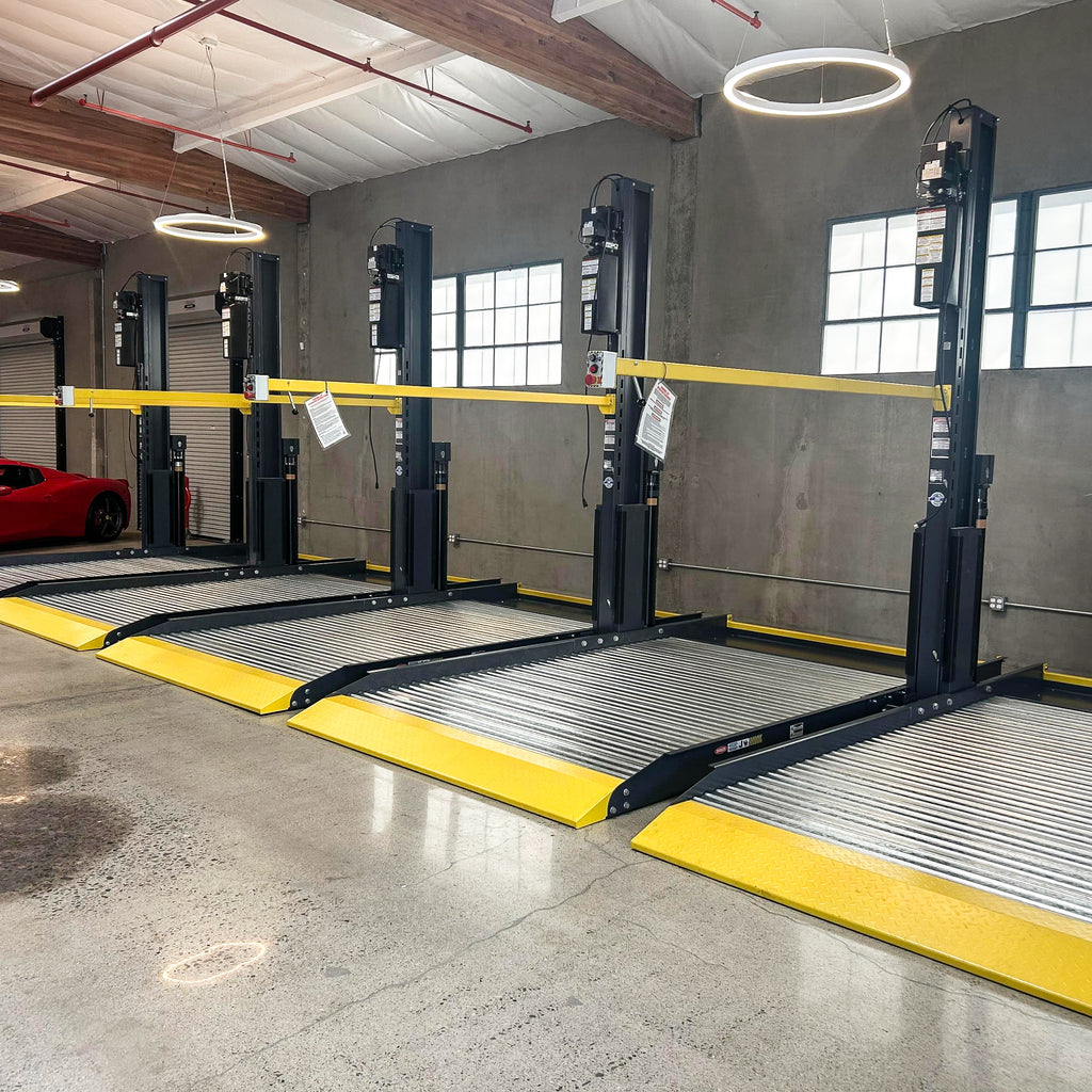 BendPak PL6000DCX two-post parking lift with shared columns and low-profile approach ramps.