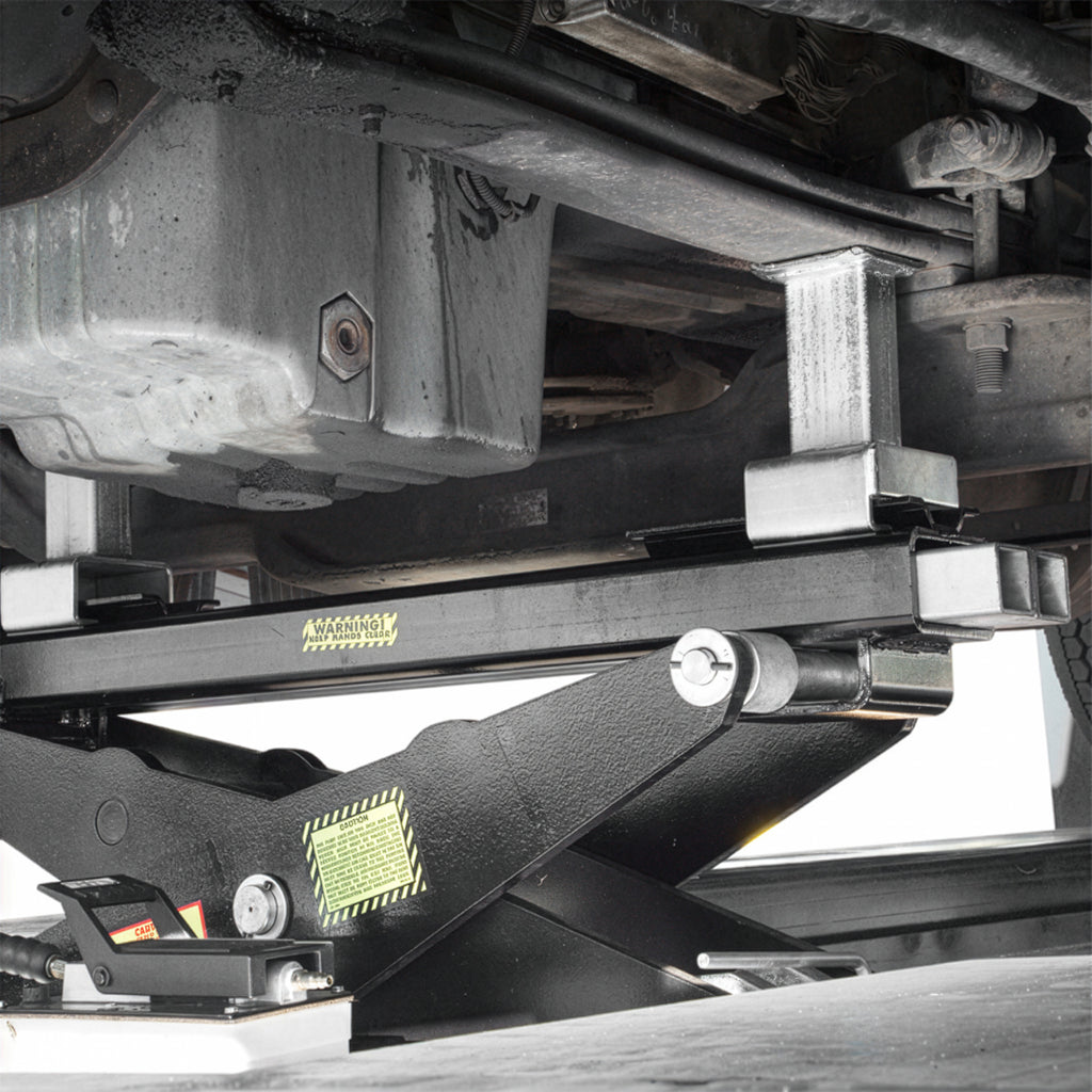 BendPak RBJ25000 rolling bridge jack lifting a heavy semi chassis on a commercial lift.