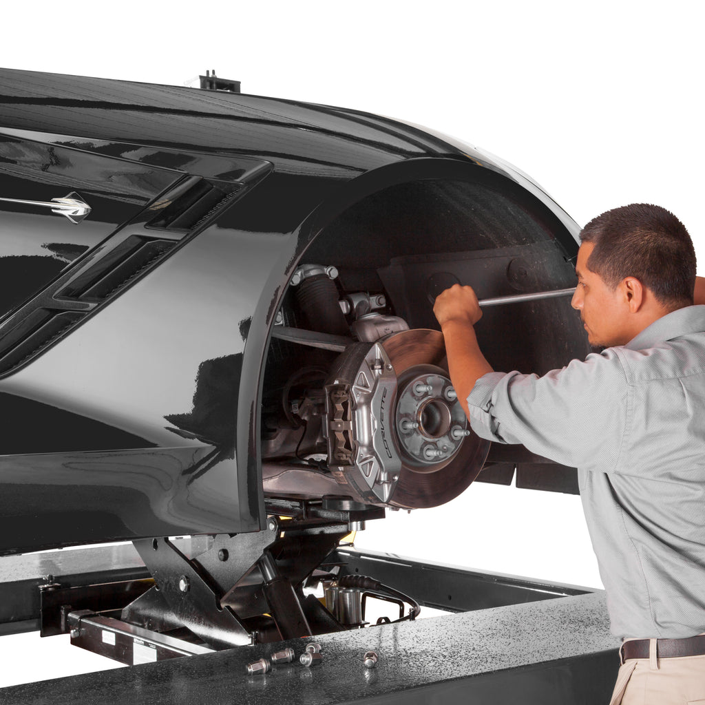 BendPak RJ45W rolling bridge jack lifting a sports car for brake pad service on a four-post lift.