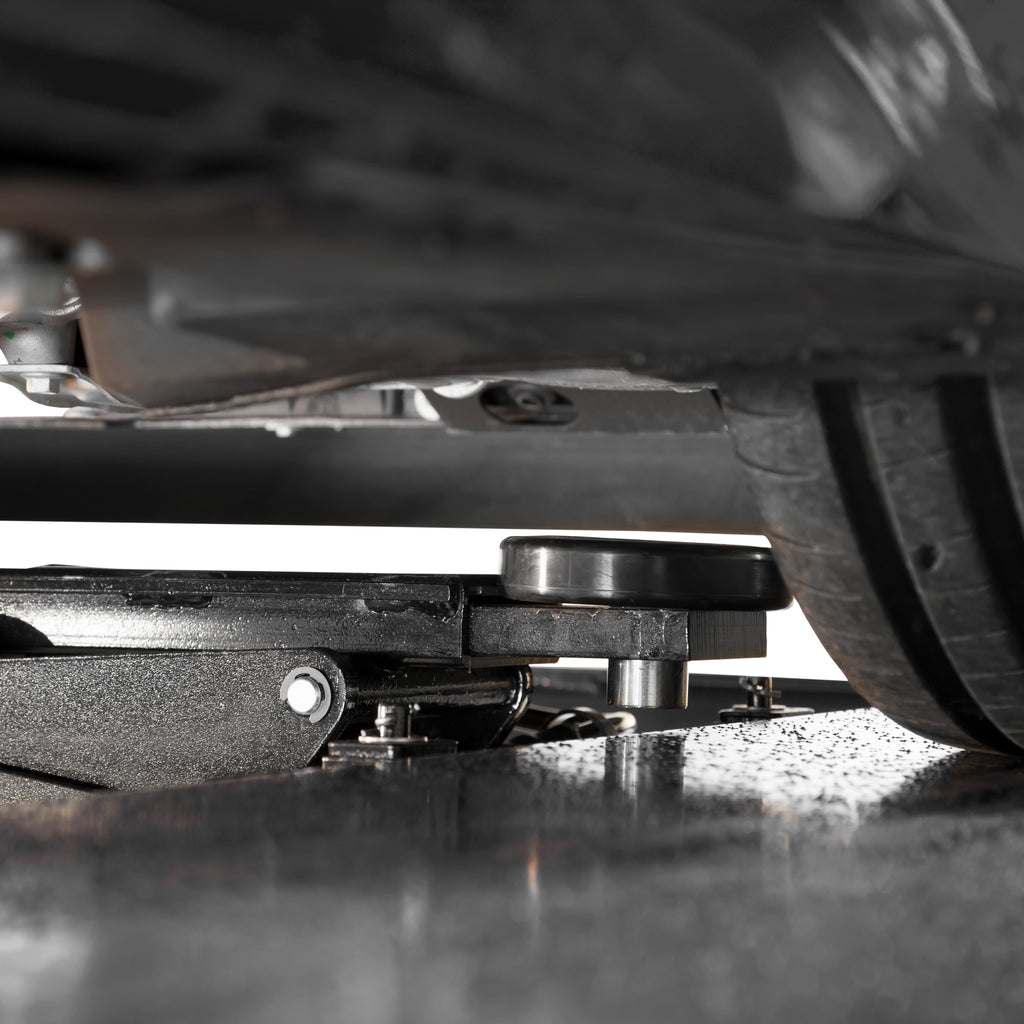 BendPak RJ45W rolling bridge jack positioned under a sports car for undercarriage access.