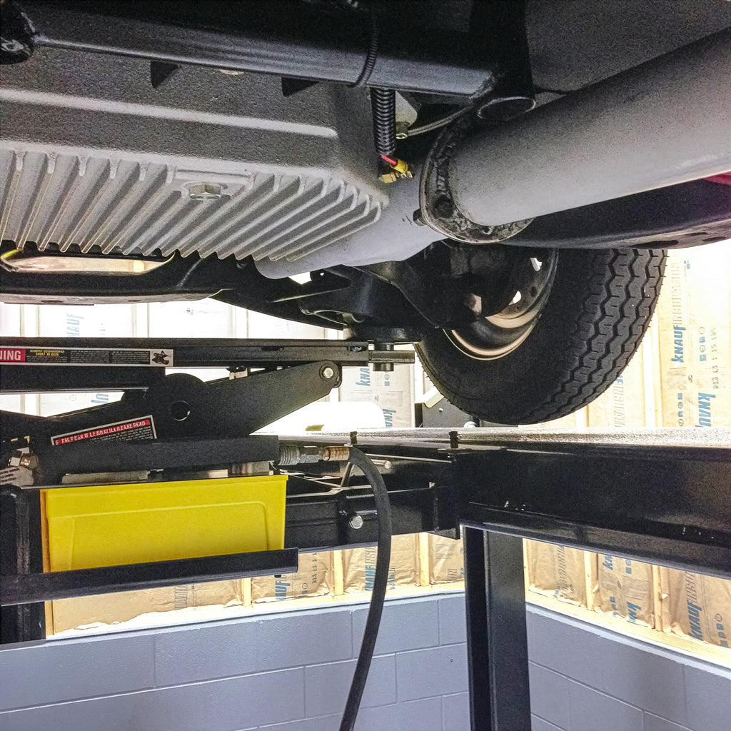 BendPak RJ45W rolling bridge jack positioned under a vehicle for undercarriage service access.