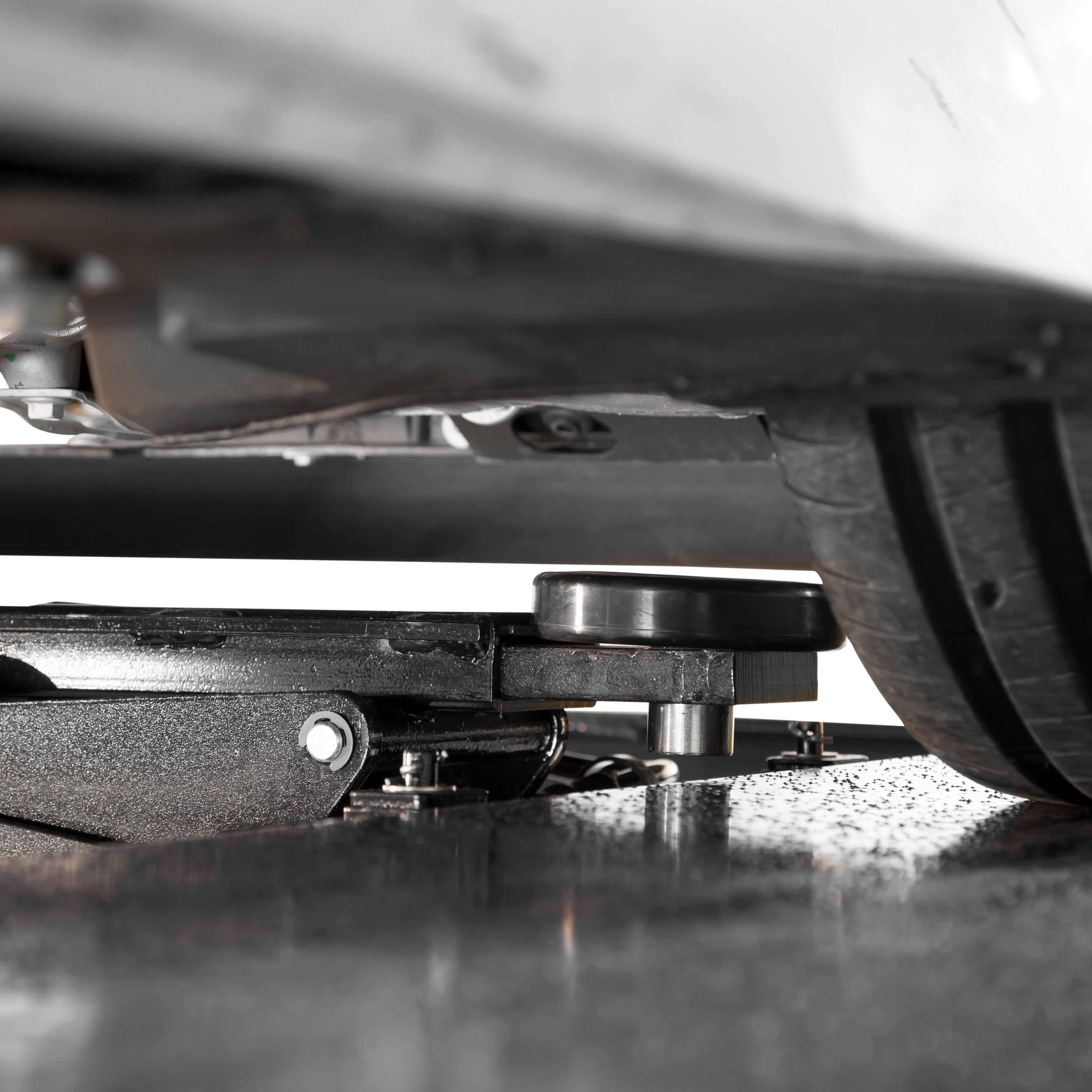 BendPak RJ6W rolling bridge jack under a sports car for wheel and undercarriage service.