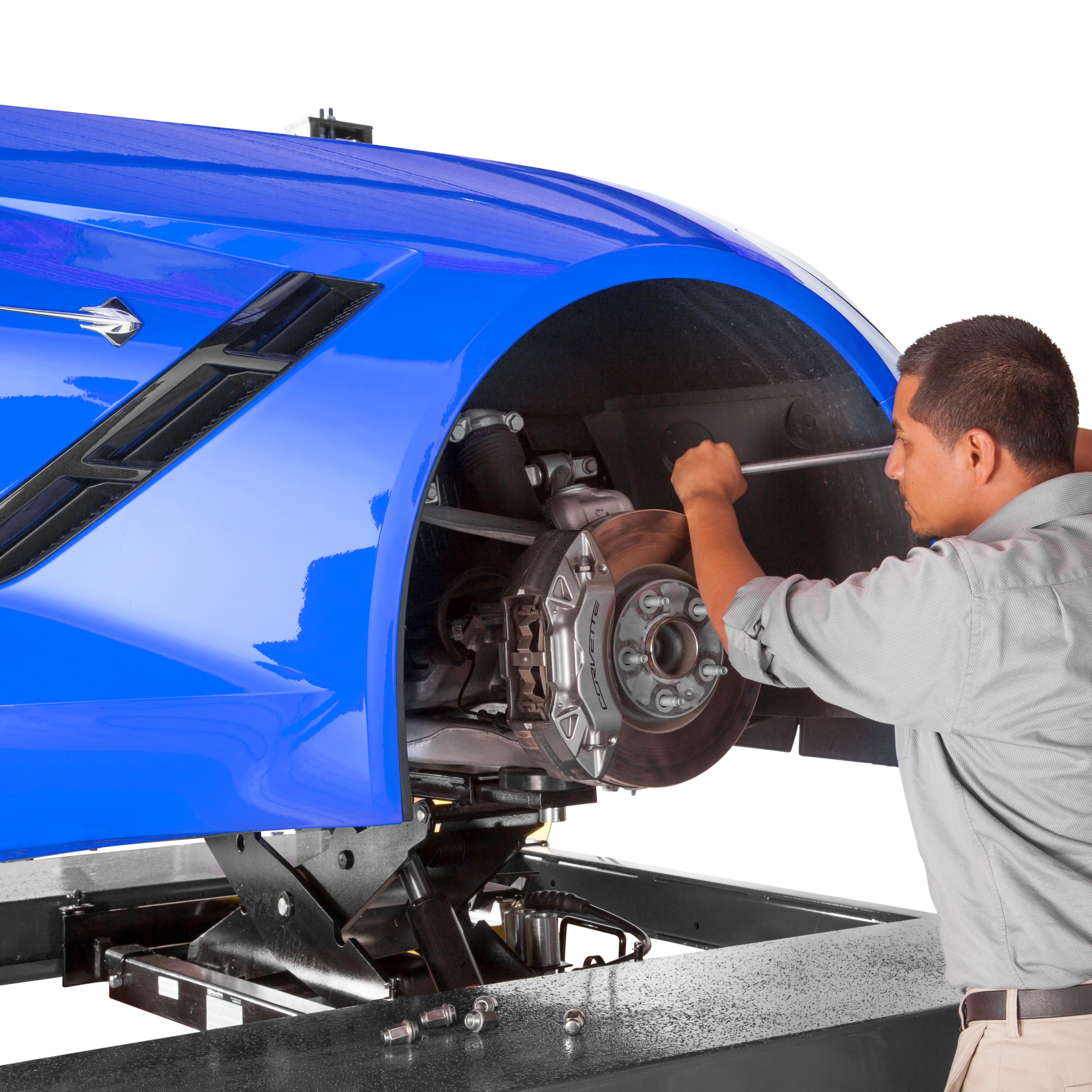 BendPak RJ7W rolling bridge jack lifting a sports car for brake pad replacement work.