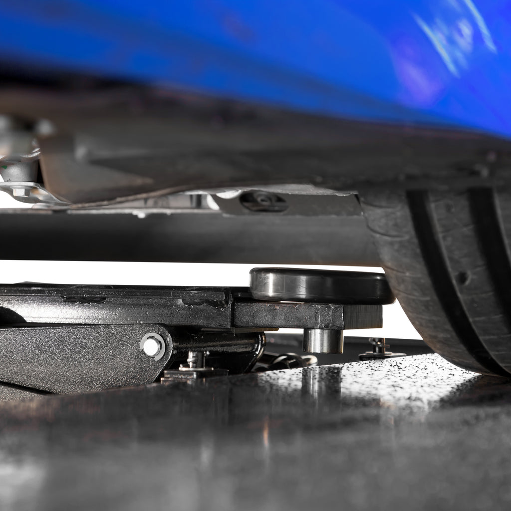 BendPak RJ7W rolling bridge jack positioned under a sports car for underbody service.