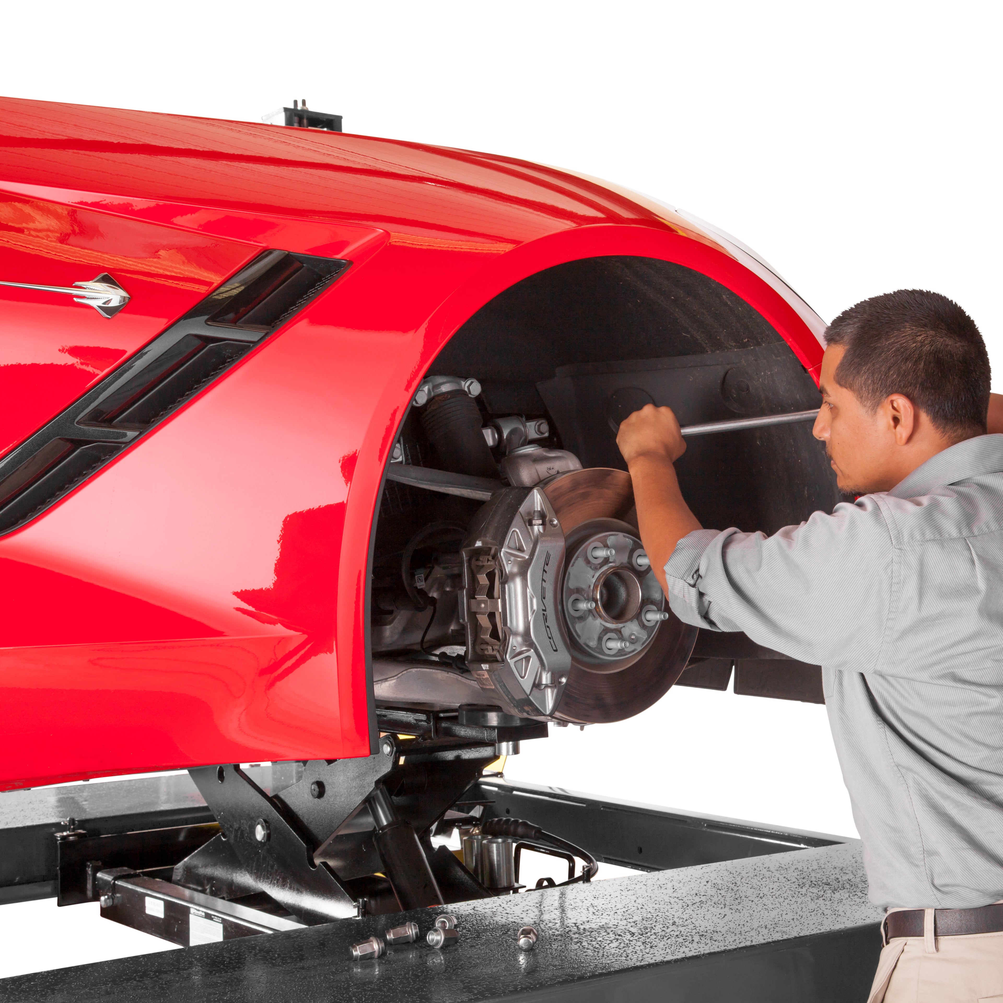 BendPak RJ9W rolling bridge jack lifting a sports car for brake pad service.