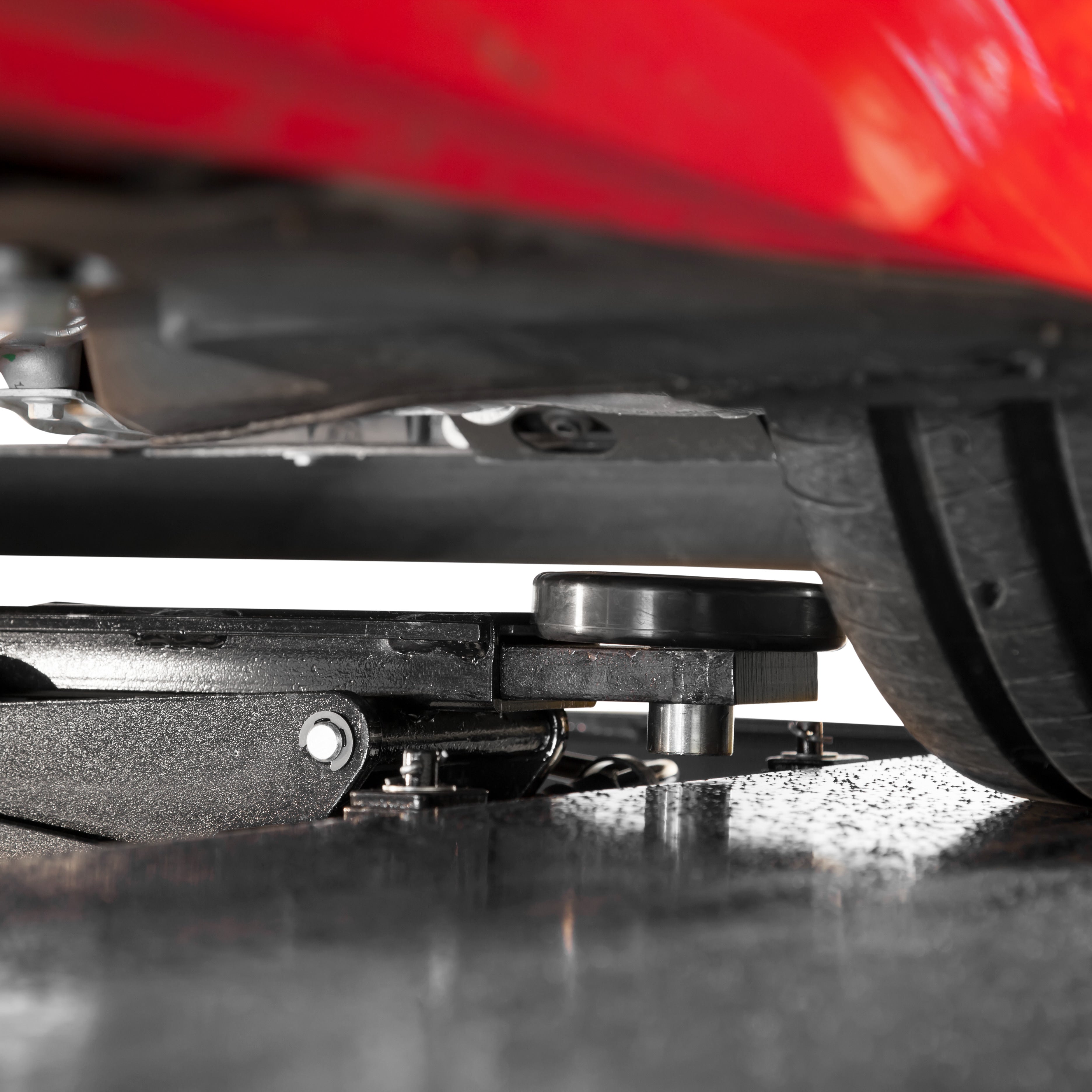 BendPak RJ9W rolling bridge jack under a sports car for undercarriage and wheel service.
