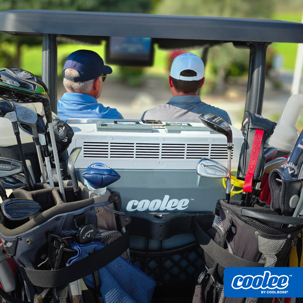 Father and son riding in a golf cart equipped with a Cool Boss COOLEE TOUR LX portable air cooler.