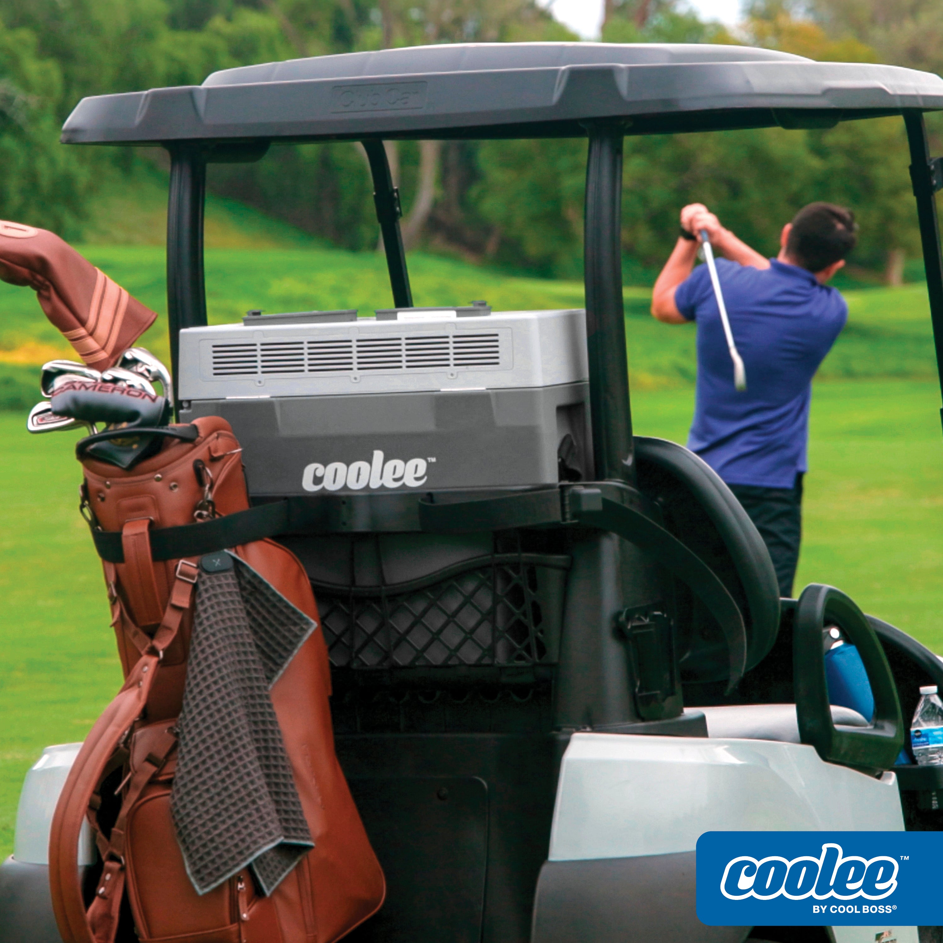 Golfer swinging a club beside a golf cart equipped with a Cool Boss COOLEE TOUR LX portable air cooler.