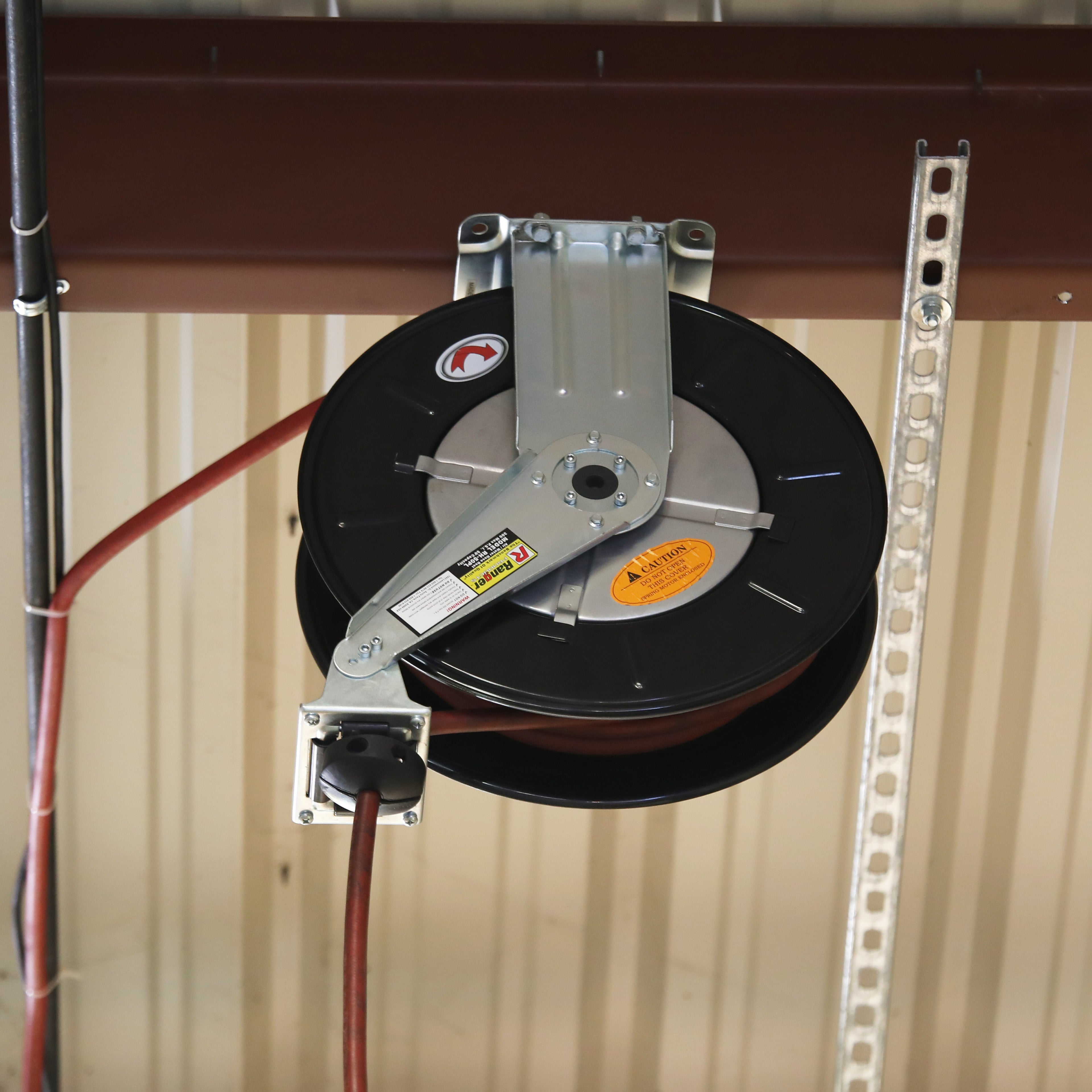 Overhead installation of a Ranger RH-50PL retractable air hose reel mounted securely to an overhead garage ceiling with the hose extended downward.
