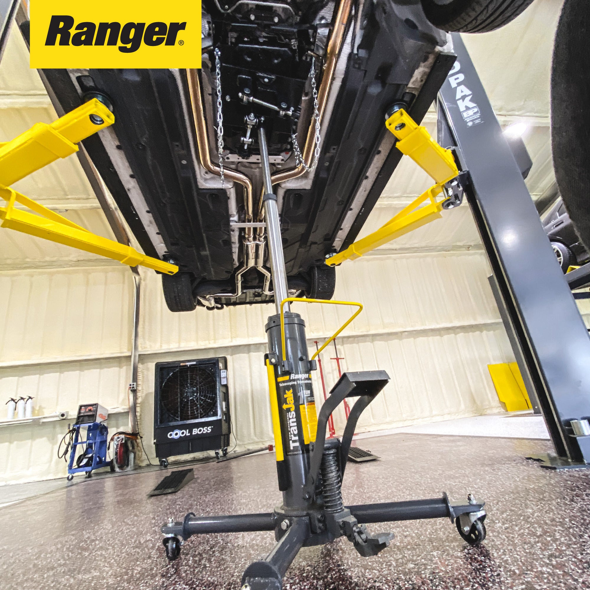 Ranger RTJ-1 transmission jack positioned under two-post lift